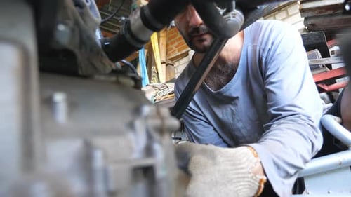 Man Repairs Car Engine in Garage