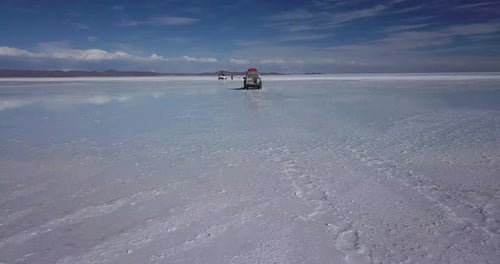 Vehicle Driving Across White Desert Landscape