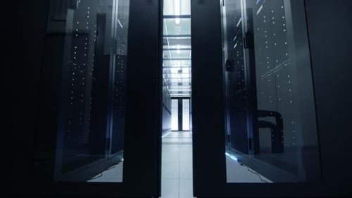 Camera Moves Through Opening Doors Into Data Center. Rack Servers are Ultra Modern and Lit by LED L