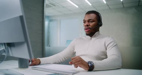 Man Wearing Headset Working at Computer in Office