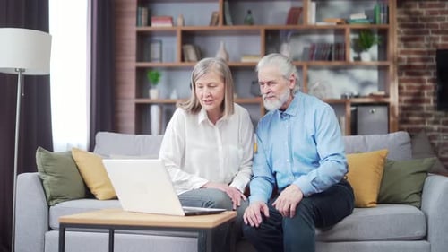 Senior Couple Video Calling with Family on Laptop