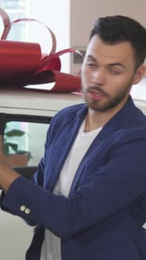 Young Salesman Assisting Mature Customer in Selecting Car Tires