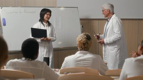 Medical Student Presenting and Receiving Applause in Lecture Hall with Board