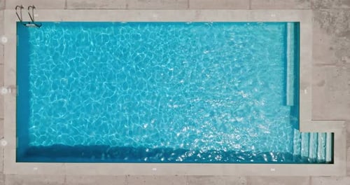 Blue Water in the Swimming Pool with Light Reflections