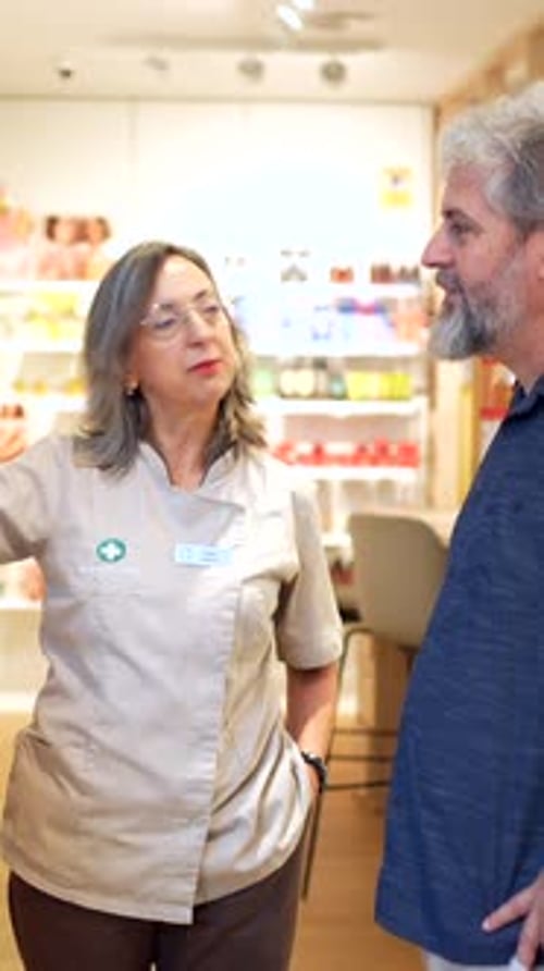Un pharmacien utilise un ordinateur pour donner des explications à un client