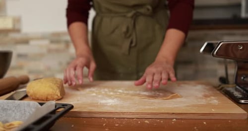 Woman Dusting Flour on Fresh Pasta Dough in a Home Kitchen