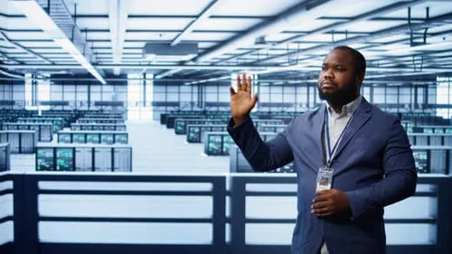 System Administrator Looking at Holograms in Data Center Monitoring Equipment