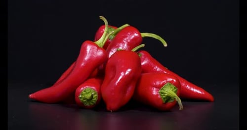 Pile of Red Peppers on Black Background Zooming In