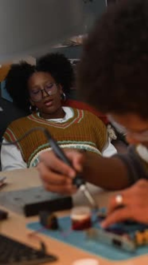 Individual Soldering Electronic Component at Table