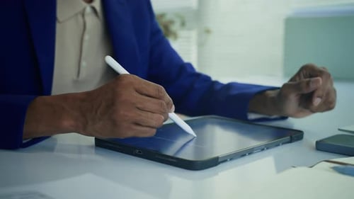 Adult Using Stylus on Tablet in Office