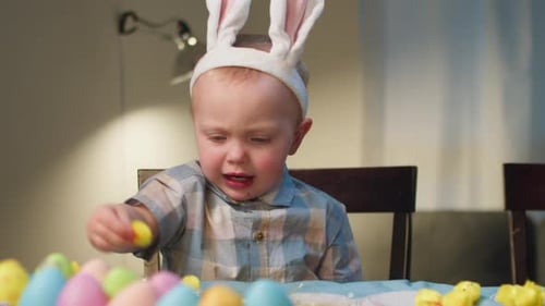 Baby mit Osterhasenohren zum Eierfärben mit der Familie Easter Joy