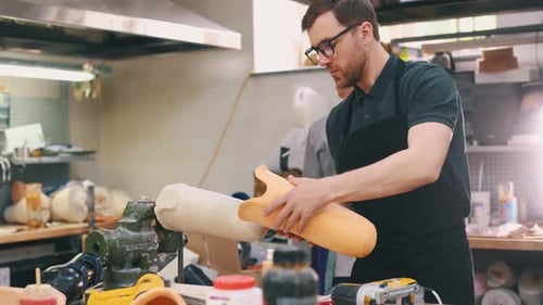 Den fertigen Guss nehmen. Techniker, der im modernen Labor mit Prothesen arbeitet