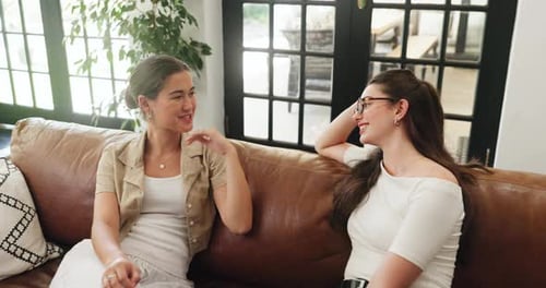 Two Women Chatting on Sofa at Home