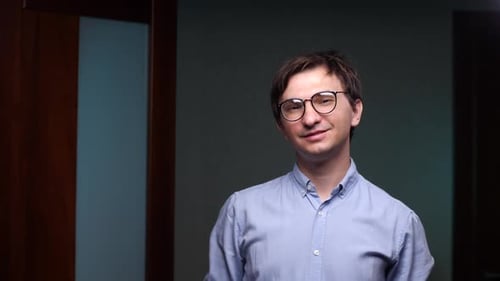 Confident Businessman Smiling in Office Corridor
