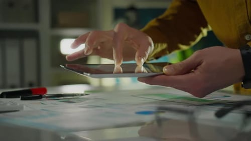Finance. Company employees in office clothes look at indicators on the tablet screen. Camera in