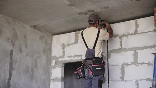 Construction Worker Drilling at a Building Site
