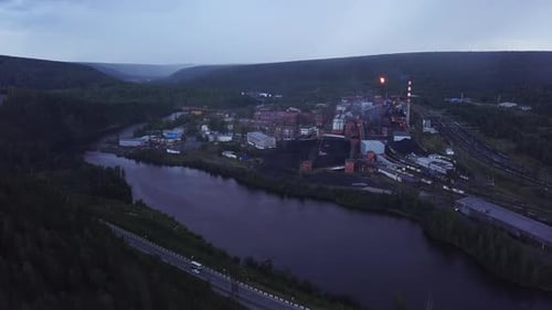 Top view of industrial city by river on summer evening
