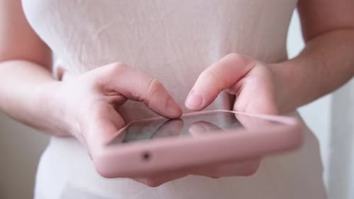 Woman Using Pink Smartphone for Communication and Technology