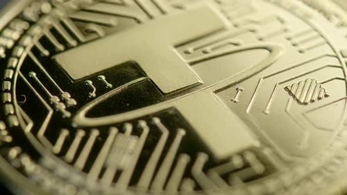 Gros plan sur la cryptomonnaie Tether dorée et brillante avec un mouvement lumineux qui brille sur le jeton