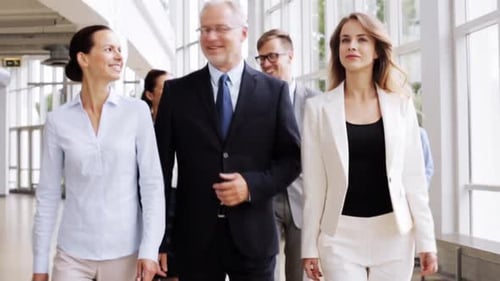 People, Work and Corporate Concept - Happy Business Team Walking Along Office