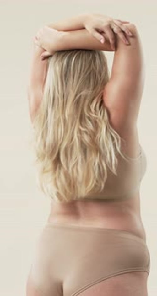 Vertical video: Embracing body positivity, plus size woman with long blonde hair posing confidently