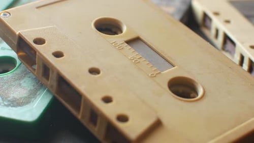 Audio cassettes on a table dolly-in extreme close-up shot. Shallow depth of field.