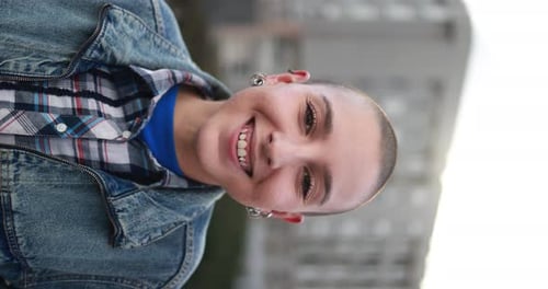 Junge glatzköpfige Frau lächelt im Freien - Vertikales Video
