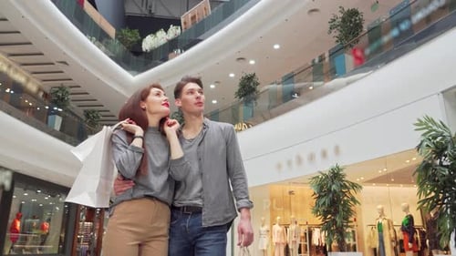 Young Couple Joyfully Exploring a Vibrant Shopping Mall