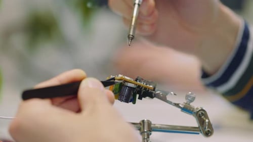 Close View of the Guy Engineer Hands Soldering Iron Circuit Board