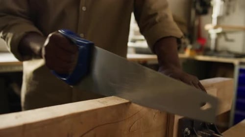 Close-Up of Carpenter Cutting Wood with Handsaw
