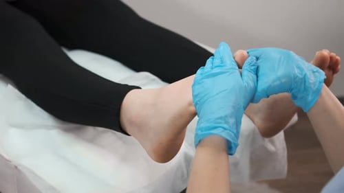 Close Up of Therapist or Podiatrist Hands Massaging Female Foot