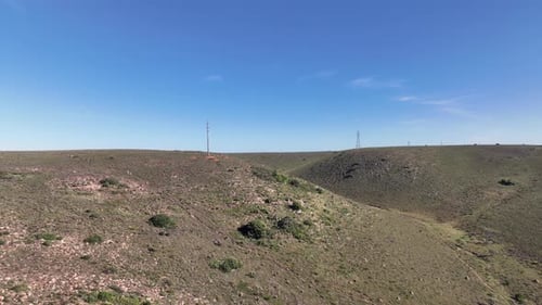 Drone flying towards hill with people seen walking