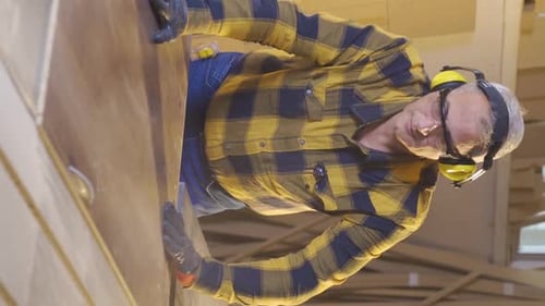 Vertical Video of Carpenter man is cutting wood in workshop.