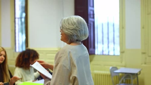 Senior Female Teacher Lecturing Students in University Classroom