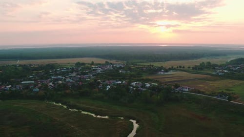 Aerial Drone Shot of Rural Village Landscape ( Dobrosloveni ) at Sunrise or Sunset with Forest