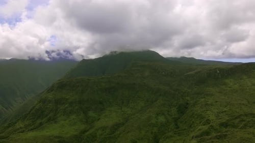Rainforest mountain range on Maui island, green peak in clouds, aerial view
