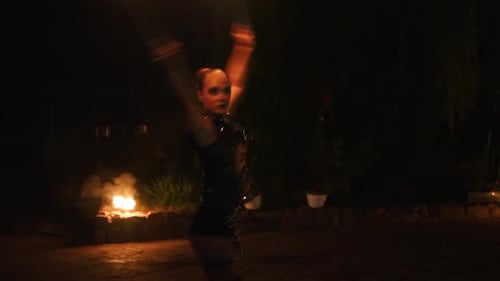 Skilled Woman Dancing with Fire at Night