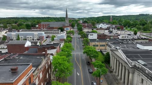 Main Street of American town in Pennsylvania. Old church and buildings. Green forest trees in backgr