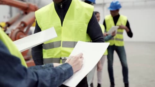 group of multiracial workers in protective helmet assembly engineers robotics factory