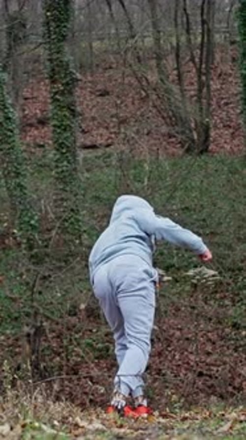 Athletic Young Man Practicing Martial Arts in Forest