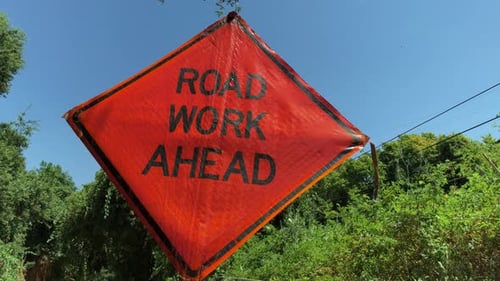 Vue à angle réduit d'un panneau d'avertissement orange « travaux à venir »
