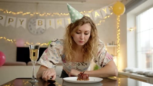 A Woman Looking at the Birthday Cake and Blowing a Candle on It Before Taking a Bite