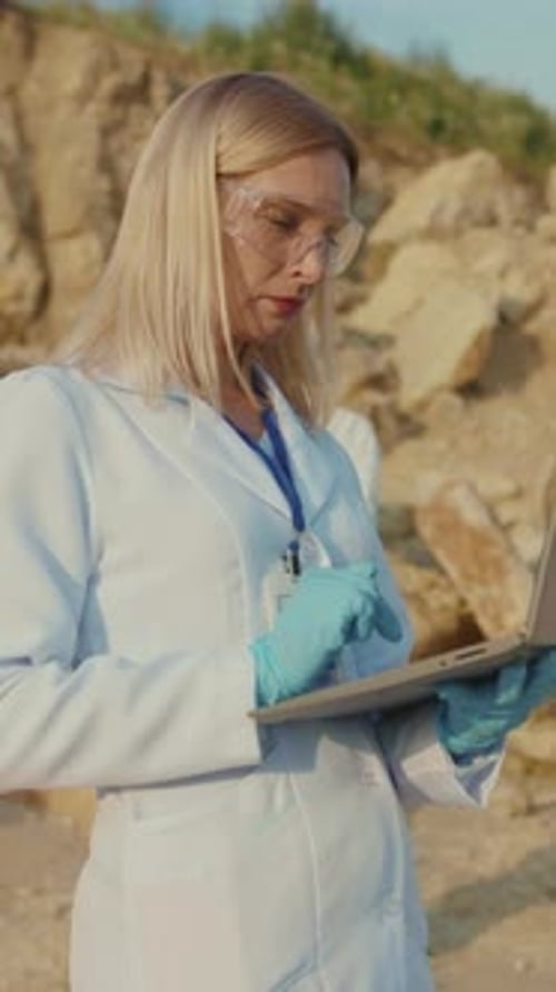 Scientist Working On Laptop On Rocky Beach