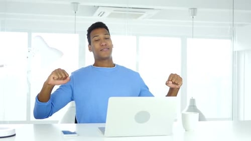 Young AfroAmerican Man Stretching and Relaxing Body in Office