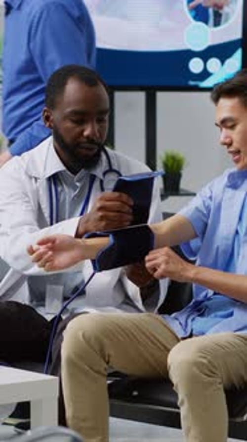 Doctor Measures Patient's Blood Pressure in Clinic
