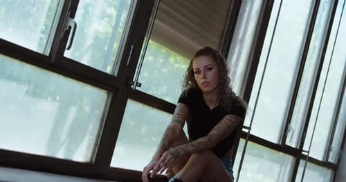 Tattooed Woman Poses in Urban Setting