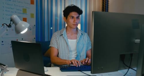 Young freelance Asia male use computer remote working on desk in living room at home.