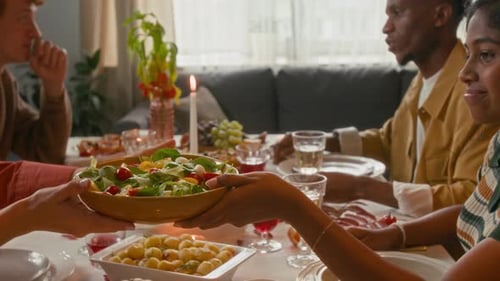 Friends Giving Salad at a Sunny Dinner Party