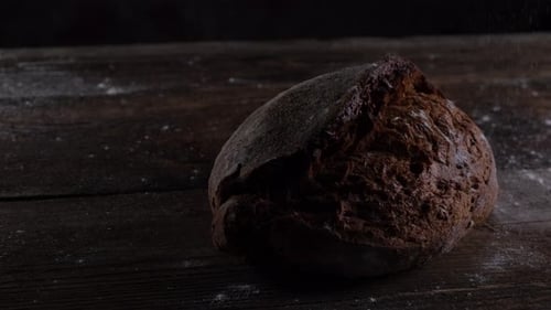 Crusty Brown Bread on Wooden Table with Flour