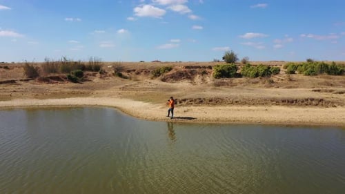 Man Photographs Lakeside Landscape on Sunny Day